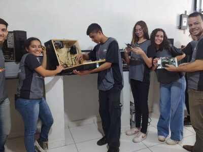À direita, Frankillin Cardoso orienta os alunos, que transformam descarte em computadores | Foto: Divulgação