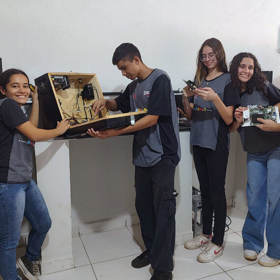 À direita, Frankillin Cardoso orienta os alunos, que transformam descarte em computadores | Foto: Divulgação