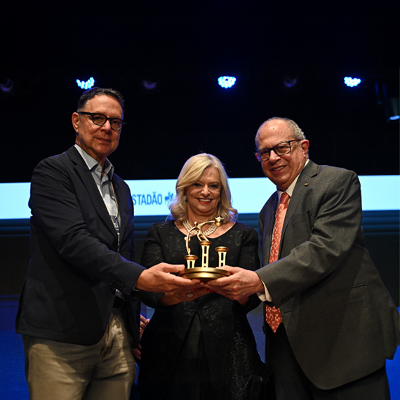 Laura Laganá, recebe o Prêmio Guerreiro da Educação pela mãos de Prof. José Augusto Minarelli (d) e Eurípedes Alcântara (e) | Foto: Roberto Sungi