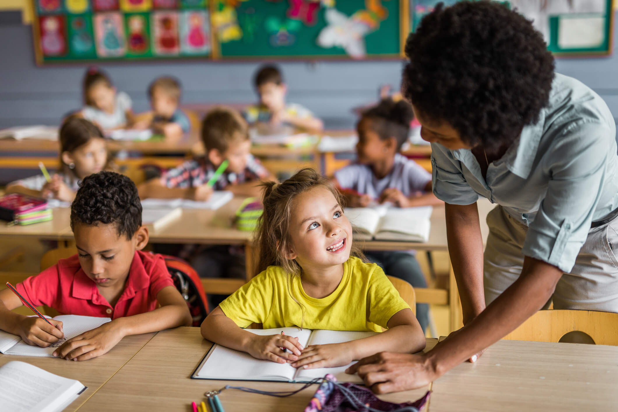 Uma professora ajudando uma aluna a fazer a tarefa.