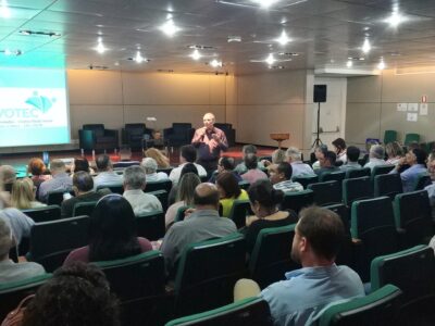 auditório com pessoas assistindo à palestra