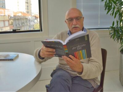 O pedagogo Jaume Carbonell sentado lendo o livro "Pedagogias do Século XXI""